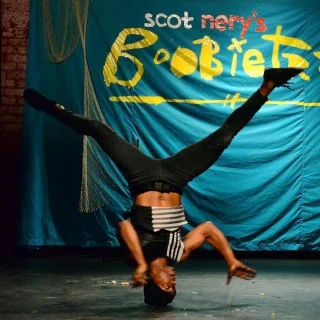 Breakdancer performing a headstand on stage at Scot Nery's Boobietrap
