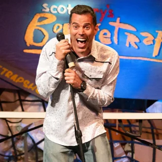 Scot Nery performing on stage at Scot Nery's Boobietrap with a microphone